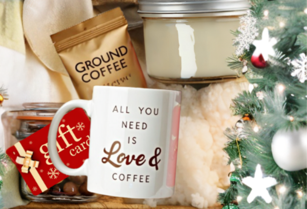 coffee-themed Christmas gift basket with a white mug that says 'All You Need is Love & Coffee,' a bag of ground coffee, a candle in a mason jar, chocolates, and a holiday gift card, placed near a decorated Christmas tree.