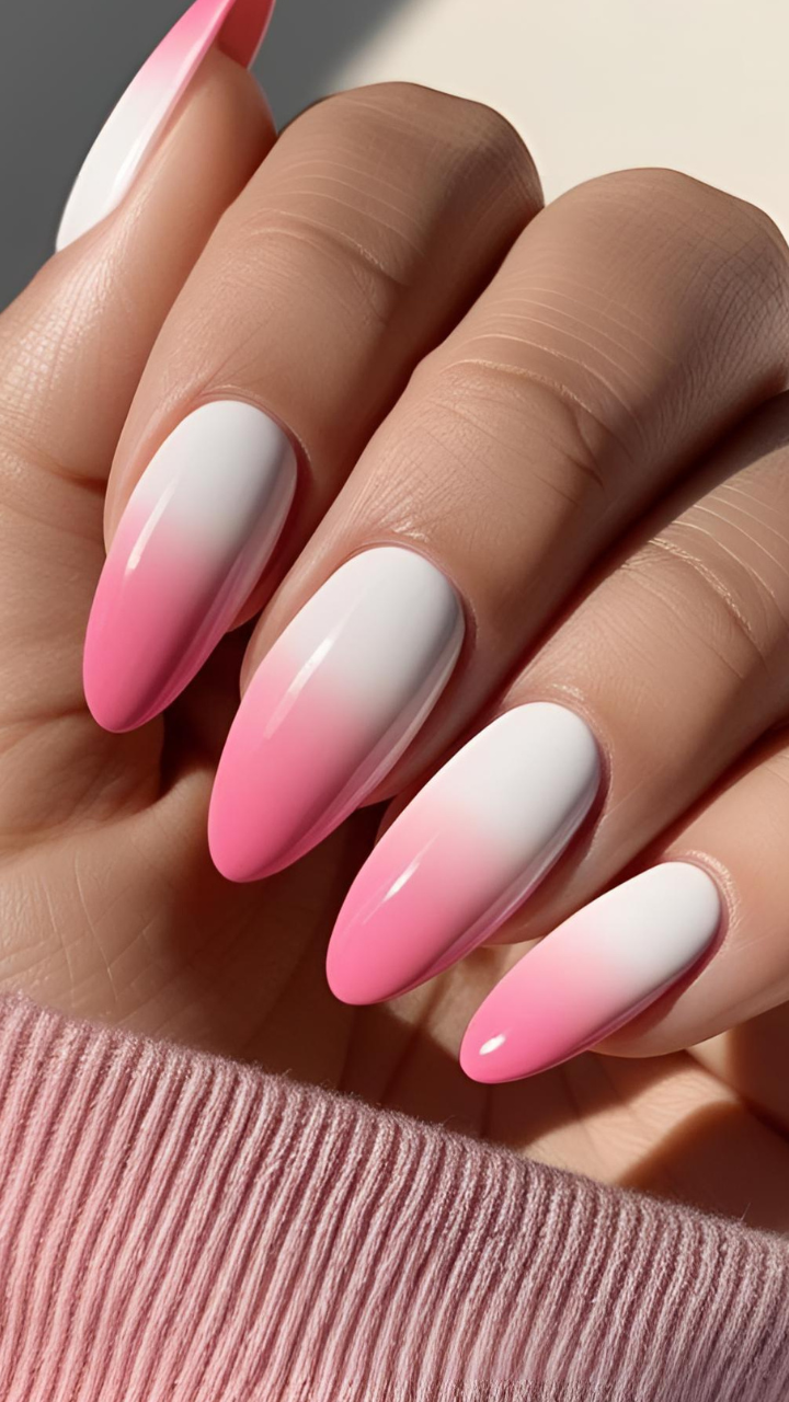 Soft pink aura nails with white-to-pink gradient ombré on almond-shaped nails.