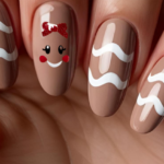 Minimalist gingerbread girl Christmas nails with brown base, white icing waves, and cute glittery red bow accent.