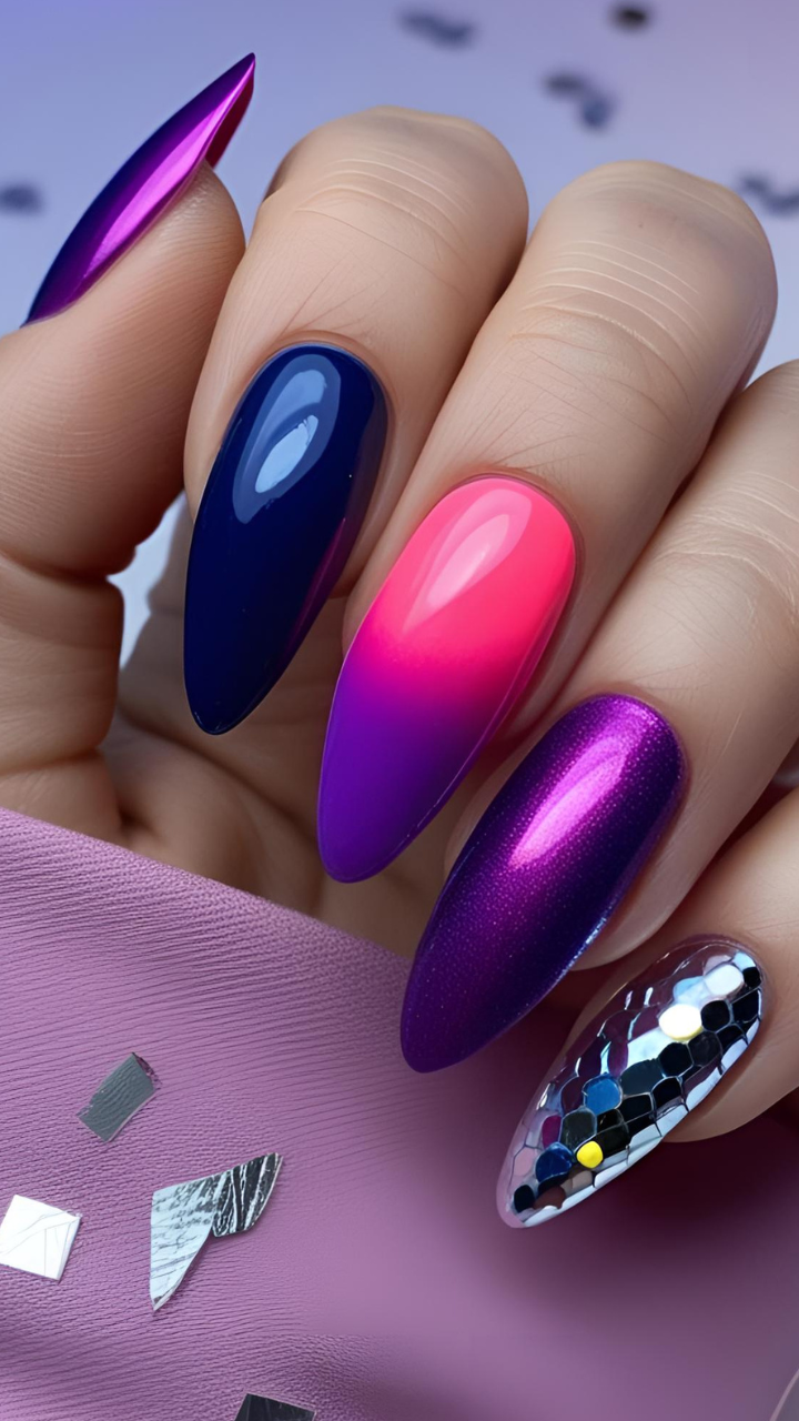 Almond-shaped nails with mixed media nail art featuring pink to purple ombre, navy blue, metallic purple, and reflective sequin accent.