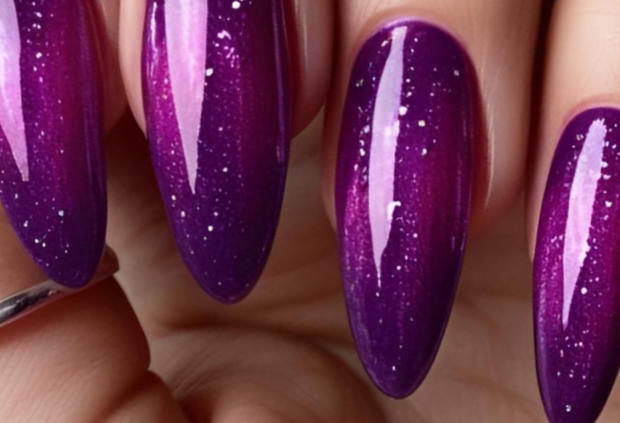 Close-up of magnetic cat eye nails in deep galaxy purple with shimmering finish.